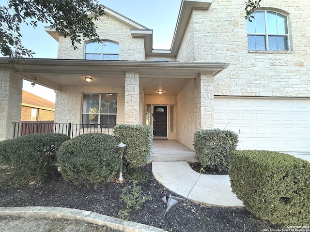 entrance to property featuring covered porch and a garage