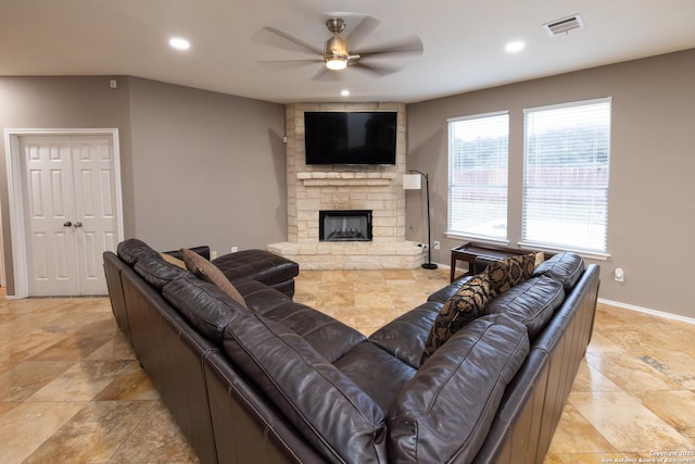 living room with ceiling fan and a fireplace