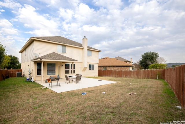 rear view of property with central air condition unit, a patio area, and a yard