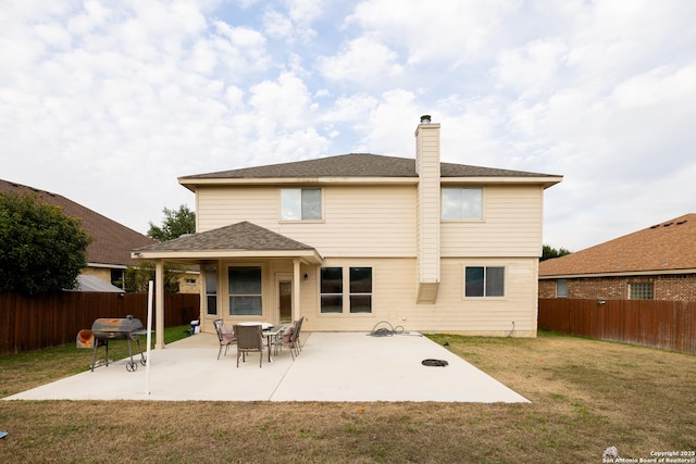 back of property with a lawn and a patio area