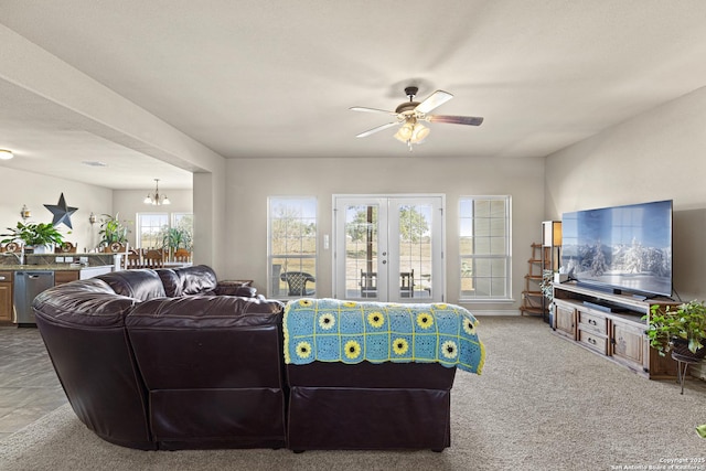 carpeted living room with ceiling fan with notable chandelier