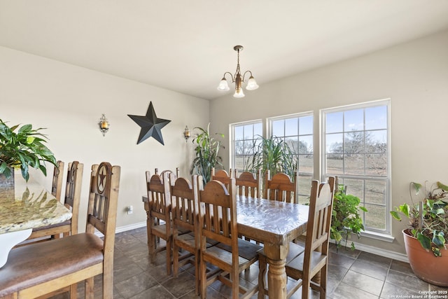 dining space featuring dark tile patterned flooring and an inviting chandelier