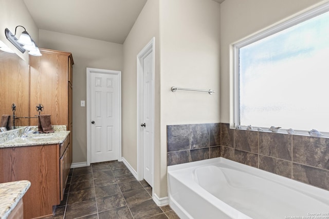 bathroom with a washtub and vanity