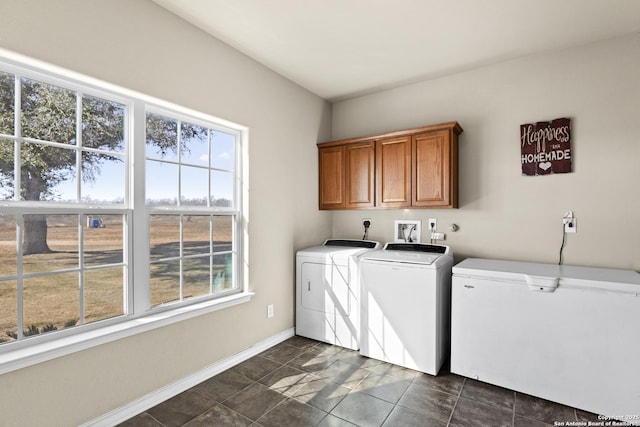 laundry room featuring cabinets, independent washer and dryer, and dark tile patterned floors