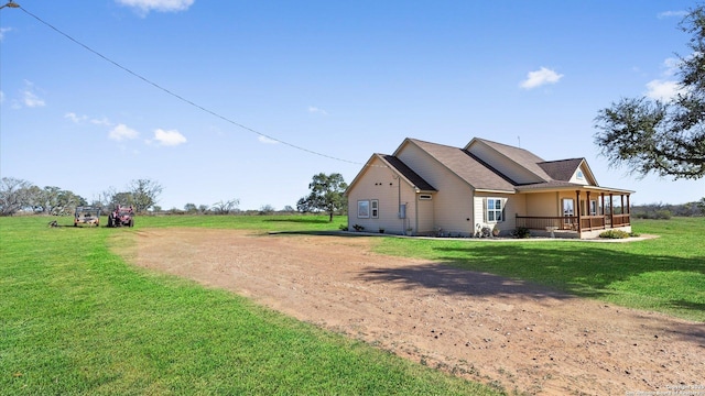 view of side of home with a porch and a lawn