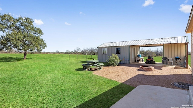 view of yard featuring an outdoor structure and an outdoor fire pit