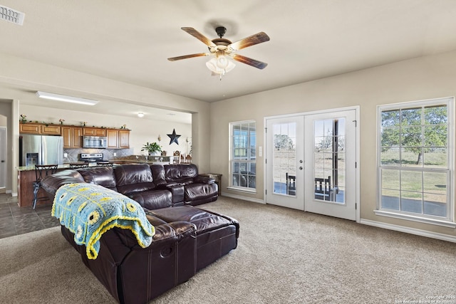 carpeted living room with french doors and ceiling fan