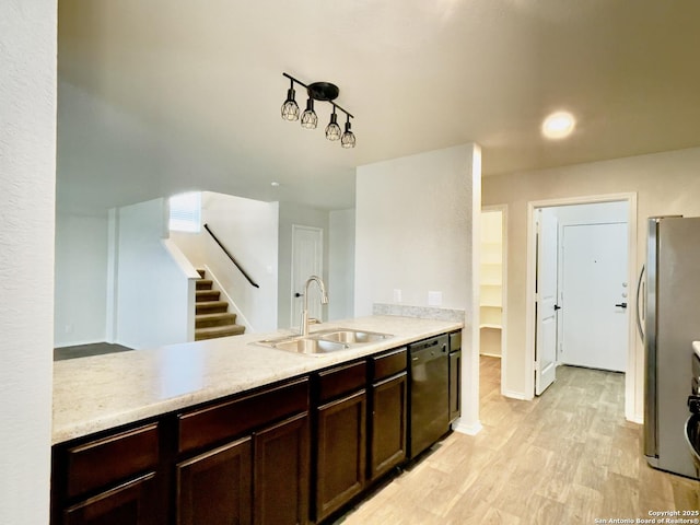 kitchen with kitchen peninsula, stainless steel fridge, black dishwasher, and sink