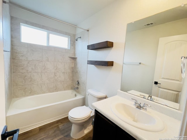 full bathroom featuring wood-type flooring, vanity, toilet, and tiled shower / bath