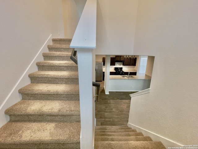 stairs with hardwood / wood-style flooring and sink