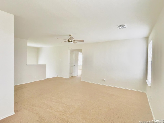 carpeted empty room featuring ceiling fan and a healthy amount of sunlight