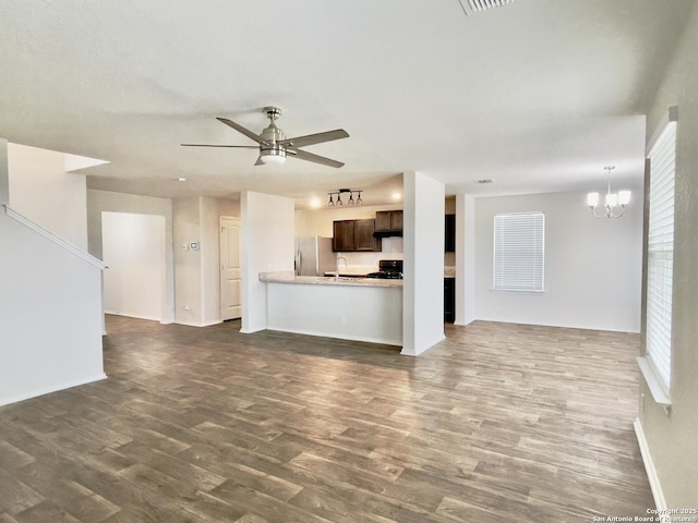 unfurnished living room featuring dark hardwood / wood-style flooring, ceiling fan with notable chandelier, and sink