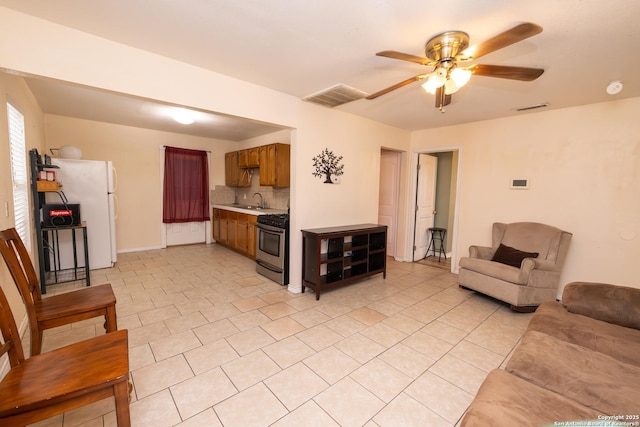 tiled living room with ceiling fan and sink