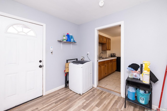 clothes washing area featuring hookup for a washing machine, light wood-type flooring, and sink