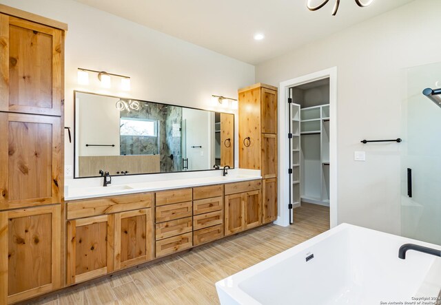 bathroom featuring vanity, hardwood / wood-style flooring, and separate shower and tub