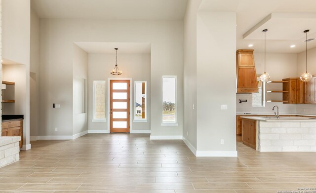 entryway featuring a towering ceiling and an inviting chandelier