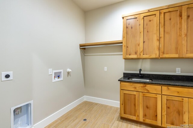 washroom featuring cabinets, hookup for a washing machine, electric dryer hookup, sink, and light hardwood / wood-style floors