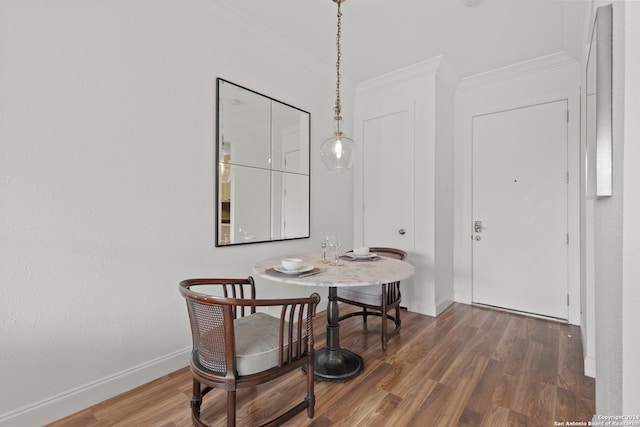 dining area with crown molding, baseboards, and wood finished floors