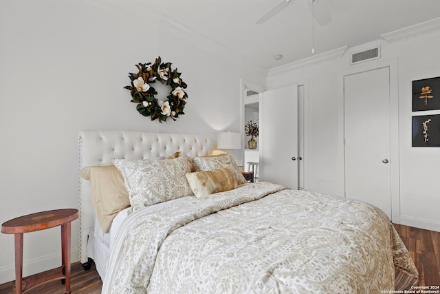 bedroom with visible vents, ornamental molding, ceiling fan, and wood finished floors