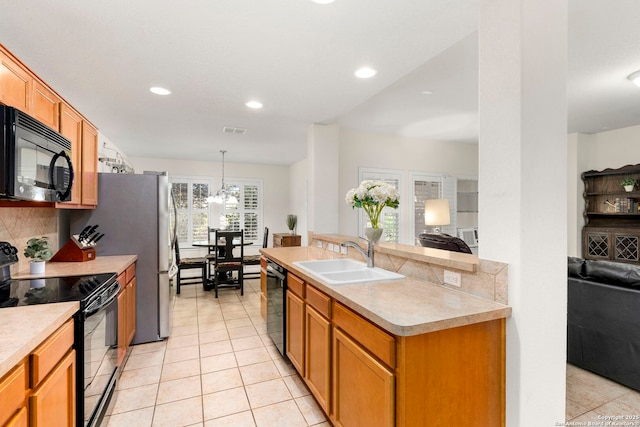 kitchen featuring tasteful backsplash, sink, black appliances, pendant lighting, and light tile patterned flooring