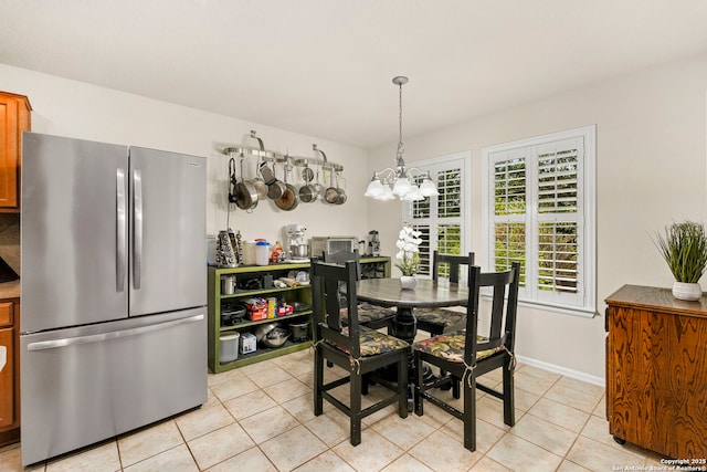 tiled dining area featuring a chandelier