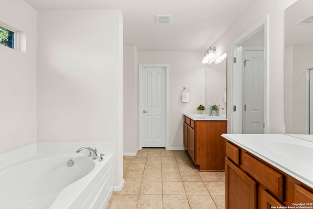 bathroom with tile patterned flooring, a bath, and vanity