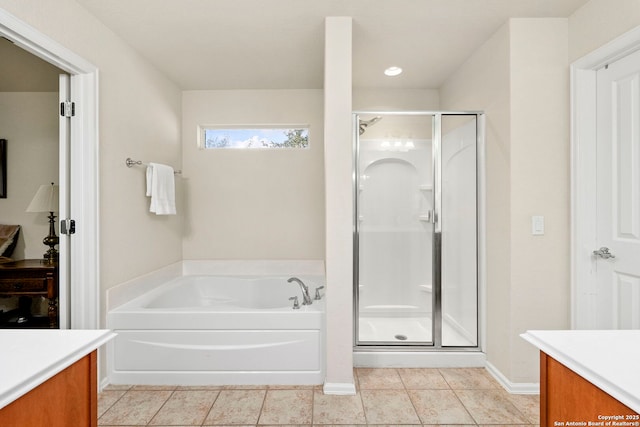 bathroom featuring plus walk in shower, vanity, and tile patterned flooring