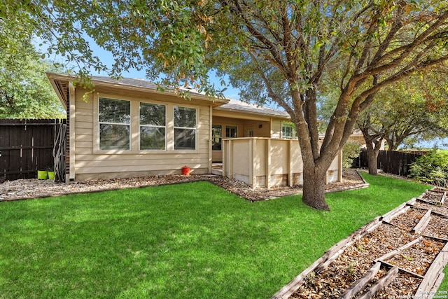 back of house with a yard and a pool