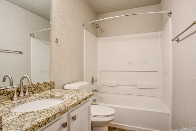 full bathroom with a textured ceiling, vanity, toilet, and tub / shower combination