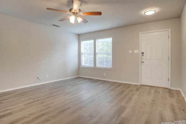 entryway with ceiling fan, light hardwood / wood-style floors, and a textured ceiling