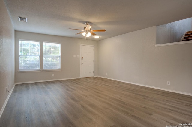 empty room featuring a textured ceiling, dark hardwood / wood-style flooring, and ceiling fan