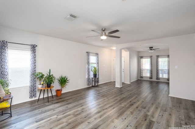 empty room featuring ceiling fan, plenty of natural light, and hardwood / wood-style flooring