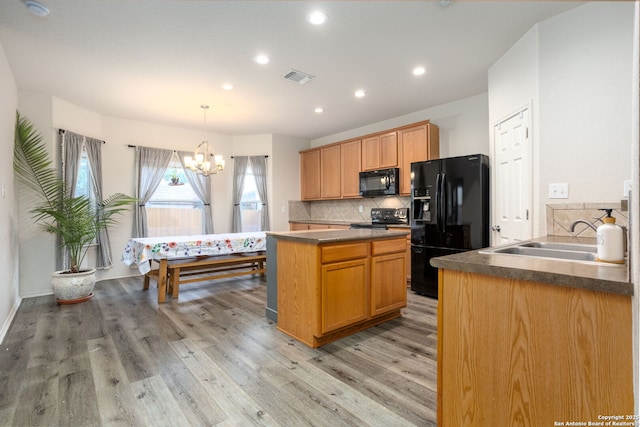 kitchen featuring sink, an inviting chandelier, light hardwood / wood-style floors, decorative backsplash, and black appliances