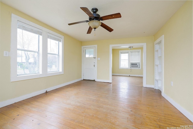 interior space with ceiling fan, cooling unit, and light wood-type flooring