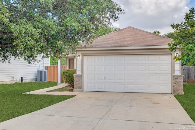 view of front facade featuring central AC unit, a front yard, and a garage