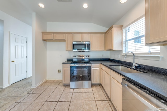 kitchen with sink, stainless steel appliances, vaulted ceiling, and light brown cabinets