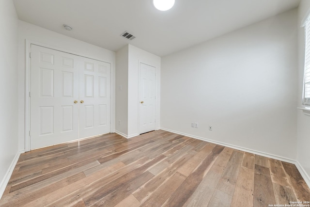 unfurnished bedroom with hardwood / wood-style floors and a closet