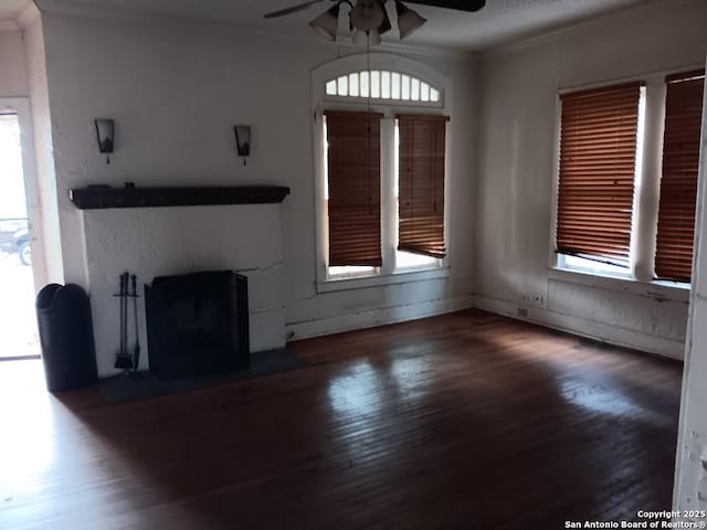 unfurnished living room with dark hardwood / wood-style floors, a wealth of natural light, and ceiling fan