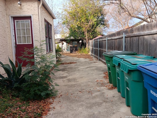 view of side of property featuring a storage unit and a patio area