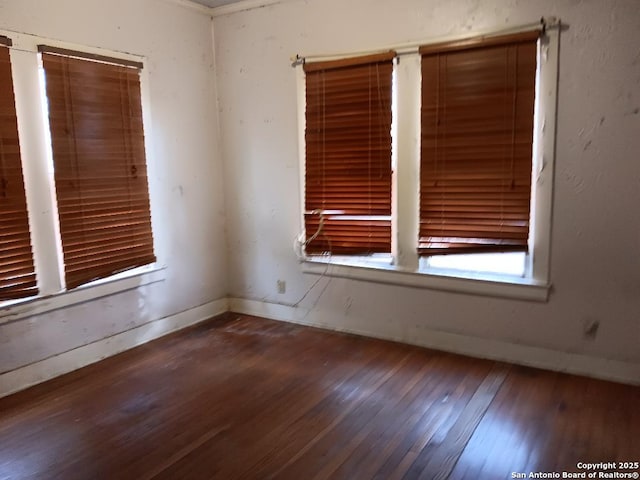 unfurnished room with dark wood-type flooring