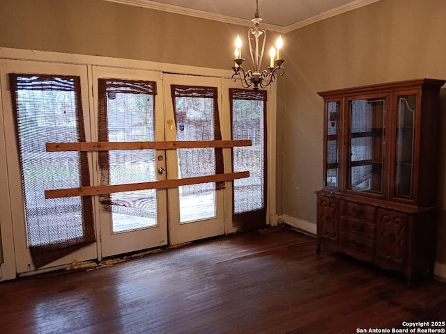 entryway with a chandelier, dark hardwood / wood-style flooring, a wealth of natural light, and ornamental molding