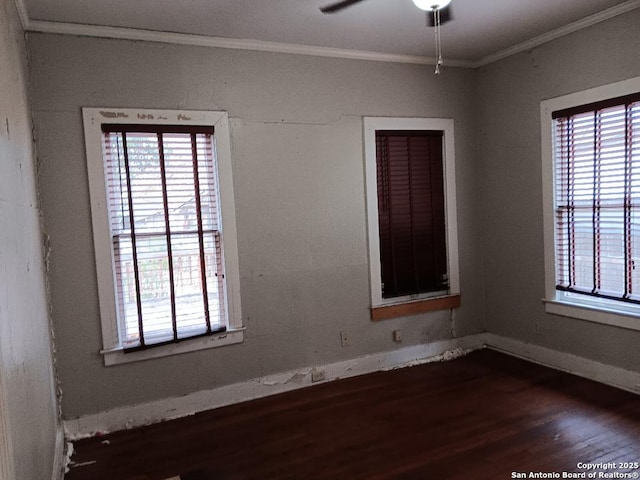 spare room with a healthy amount of sunlight, dark hardwood / wood-style floors, ceiling fan, and crown molding