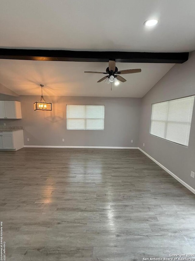 unfurnished room featuring hardwood / wood-style flooring, vaulted ceiling with beams, and ceiling fan with notable chandelier