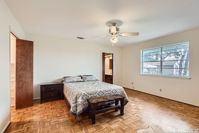 bedroom featuring ensuite bath, light parquet floors, and ceiling fan