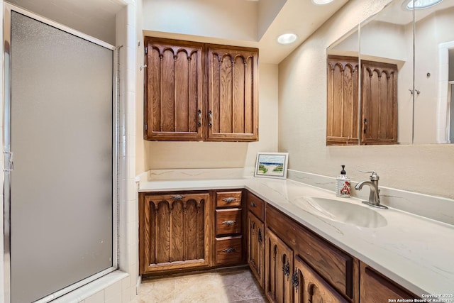 bathroom featuring a shower with shower door and vanity