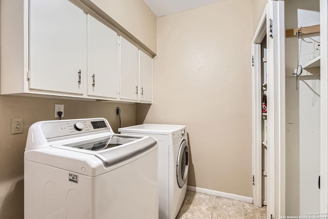 washroom featuring cabinets and washer and clothes dryer