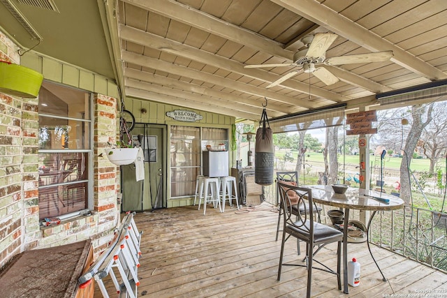 unfurnished sunroom with ceiling fan, wooden ceiling, and lofted ceiling with beams