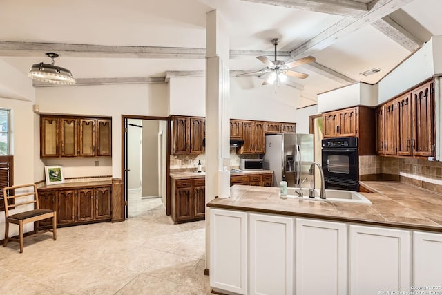 kitchen featuring tile counters, stainless steel fridge with ice dispenser, tasteful backsplash, double oven, and sink