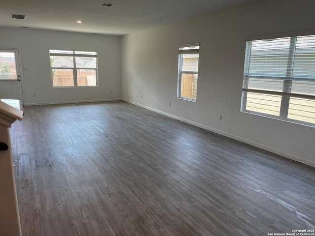 unfurnished room featuring plenty of natural light and dark hardwood / wood-style floors