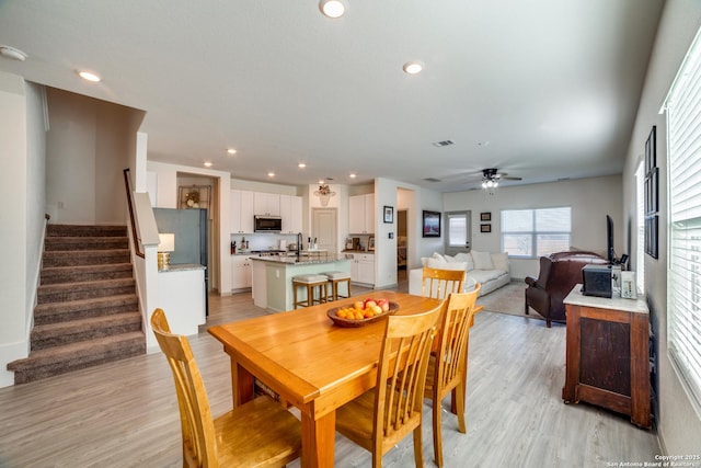 dining area with ceiling fan and light hardwood / wood-style flooring